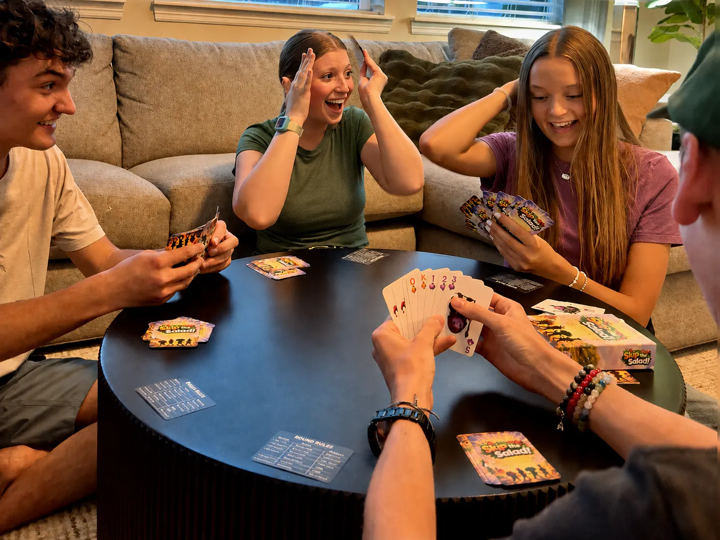Friends laughing around a table playing Skip the Salad on game night